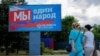 Women walk past a billboard displaying pro-Russian slogans in the Russian-occupied city of Melitopol in the Zaporizhzhya region in early August. The billboard reads: "We are one people. We are together with Russia."