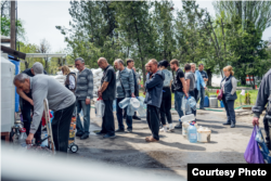 People line up at a safe water distribution point in Mykolayiv.