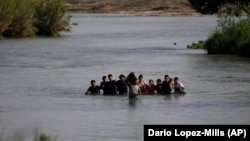 Migranți, majoritatea din Nicaragua, trec rîul Rio Grande pe la Eagle Pass, Texas, Statele Unite, 20 mai 2022.