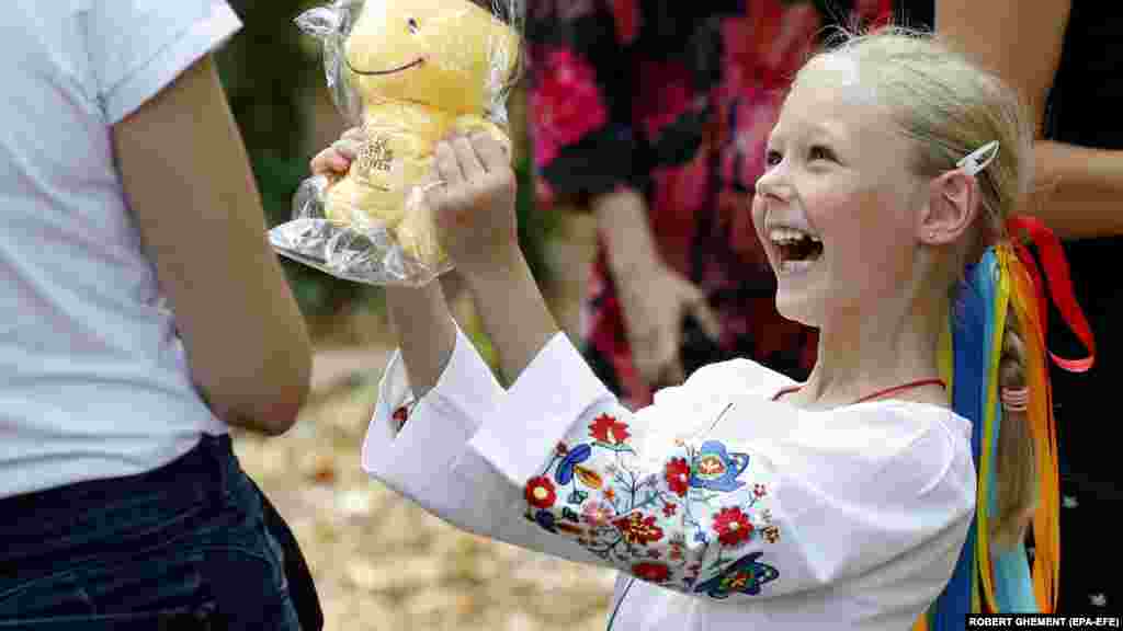 Украин кызы Румыния башкаласы Бухарестта&nbsp;качак балалар өчен үткәрелгән чарада бүләккә шатлана. 2022 елның 24 августы, украиннар бу көнне бәйсезлекнең 31 еллыгын билгеләде. (EPA-EFE/Роберт Гемент)