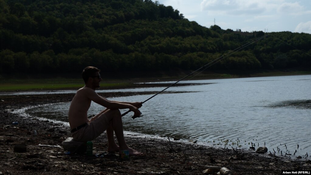 Një qytetar duke peshkuar në Liqenin e Badocit. 