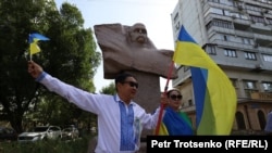 Гражданский активист Асхат Берсалимов и его сторонники проводят пикет в поддержку Украины у памятника Тарасу Шевченко в Алматы. 24 августа 2022 года