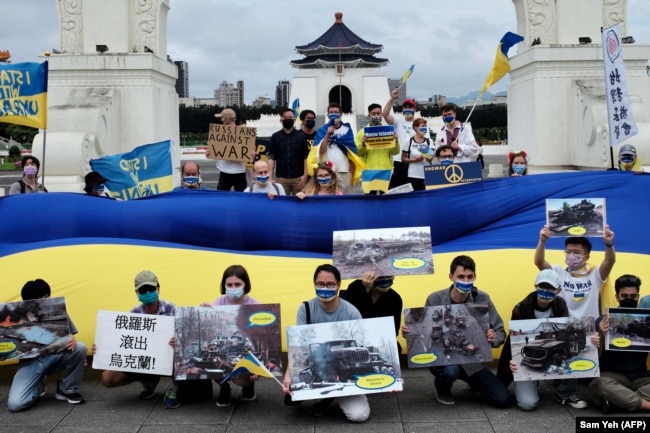 Slavic people living in Taiwan display posters and a Ukrainian flag during a rally in front of the Chiang Kai-shek Memorial Hall in Taipei on May 8, 2022.