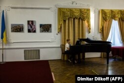 A woman plays the piano in an above-ground foyer of the Mykolayiv theater on August 25.