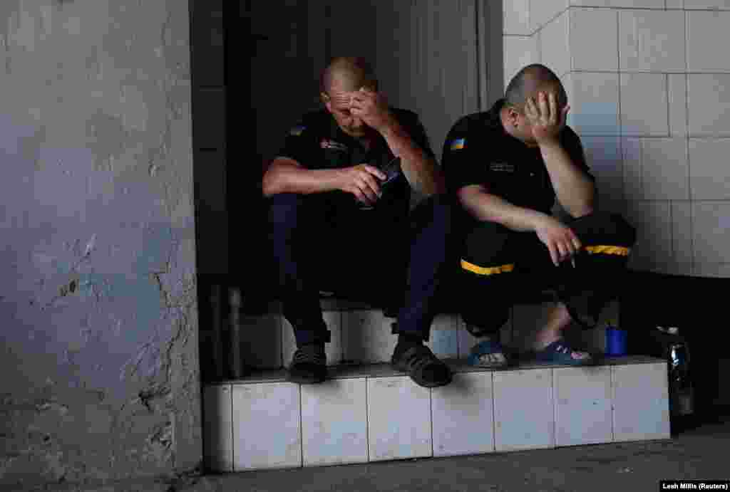 Пожежники Дмитро та Микола під час перерви між викликами читають новини на своїх телефонах, Харків, 29 червня 2022 року &nbsp;