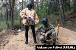 Mykhaylo and Olha, founders of Taktyka.ua, a school of tactical and combat training for civilians, wear masks during an outdoor training session near Kyiv.