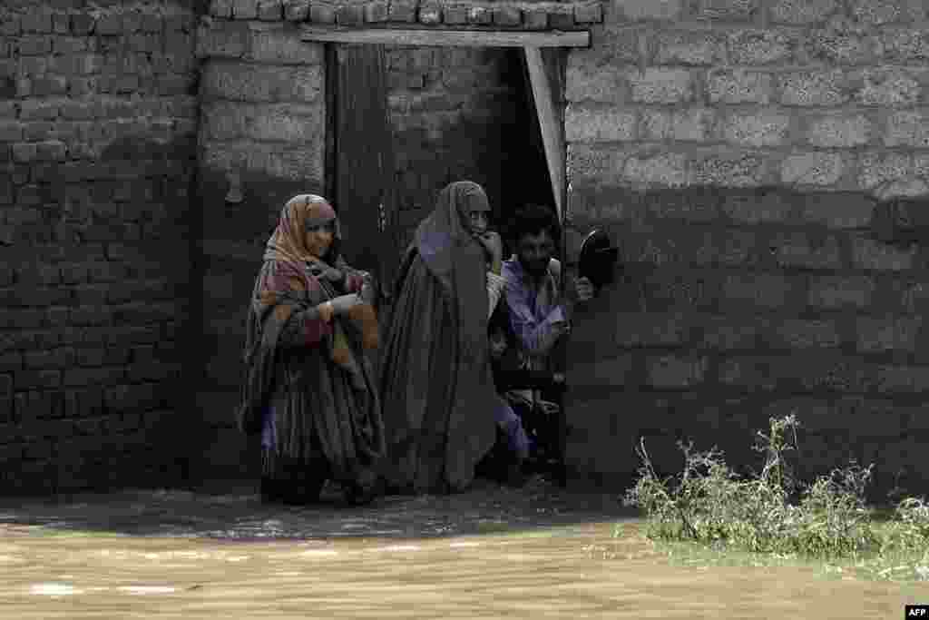 Një familje duke pritur për t&#39;u evakuuar para një shtëpie të përmbytur në rrethin Charsada të provincës Khyber Pakhtunkhva, 29 gusht. Ekipet e shpëtimit po bëjnë përpjekje për të arritur në fshatrat e izoluara në rajonet malore në veri të vendit. &nbsp;