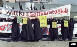 Ирански жени държат трансперанти с надписи "Светия Коран" и "Ще убием Салман Рушди" по време на демонстрация в Техеран, 17 февруари 1989 г.