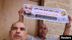 عکس محمد الحلبی در دست معترض به حکم دادگاه