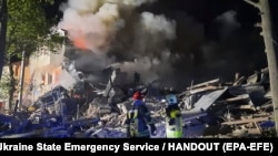 Ekipet ukrainase të shpëtimit duke shuar zjarrin, pasi një raketë goditi zonën e banimit Saltivka në Harkiv. 17 gusht 2022.