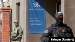 Russian police officers stand guard outside the office of Roizman Charity Fund on August 24 after its founder and politician Yevgeny Roizman was detained in Yekaterinburg.