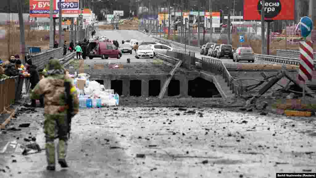 Most preko rijeke Irpin. Romanivka, 5. marta i 23. avgusta. Kako bi se zaustavilo napredovanje ruskih trupa na Kijev, dignuta su u vazduh tri mosta u Kijevskoj oblasti, uključujući i most preko rijeke Irpin. Upravo su taj most koristili ljudi da pobjegnu od rata.