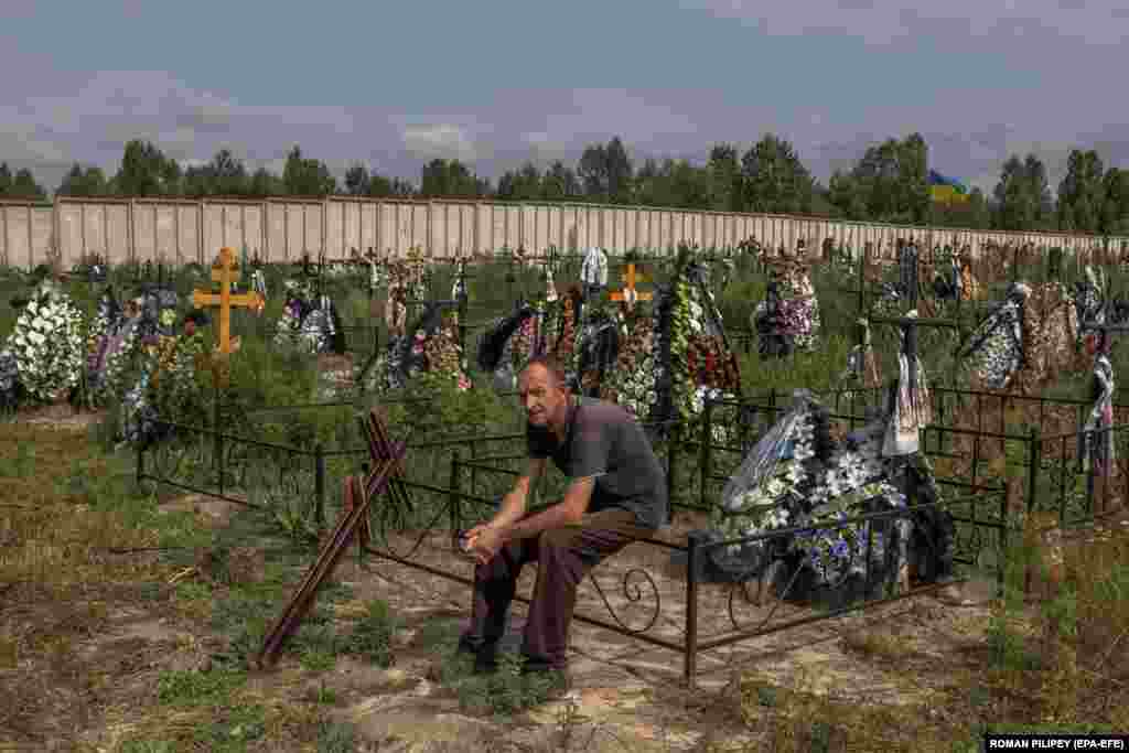A worker rests during the mass burial of unidentified people who were killed in the Bucha district at the time of the Russian occupation, at a cemetery in Bucha, northwest of Kyiv. Hundreds of tortured and killed civilians were found in Bucha and other parts of the Kyiv region after the Russian Army retreated from those areas.