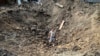 Чоловік стоїть у вирві після ракетного удару в Дергачах, на околиці Харкова, серпень 2022 року 