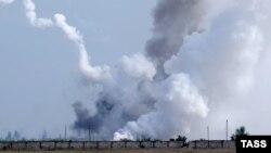 На снимке виден дым, поднимающийся над территорией после предполагаемого взрыва в селе Майское, 16 августа 2022 года