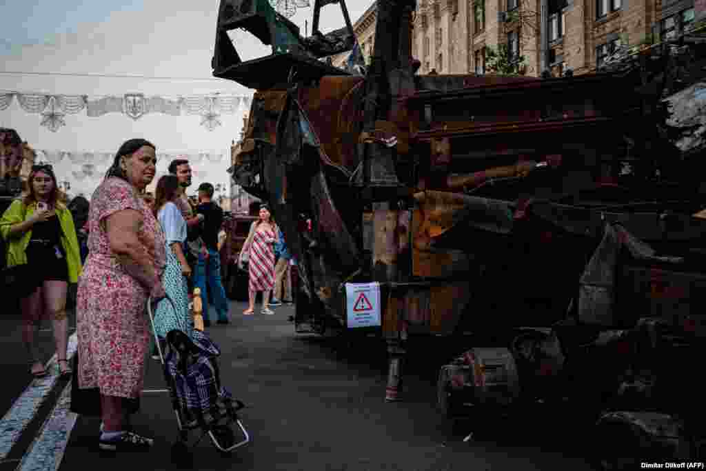 Egy idős asszony nézi a megsemmisült orosz katonai felszereléseket