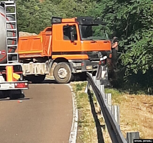 Një person i armatosur dhe me maskë në barrikadë në Jarinjë të Poshtme afër kufirit me Serbinë.