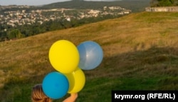 Жители Симферополя запускают воздушные шарики в цветах украинского флага на Петровских скалах. Иллюстративное фото