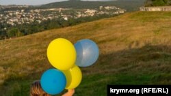 Жители Симферополя запускают воздушные шарики в цветах украинского флага на Петровских скалах, август 2022 года