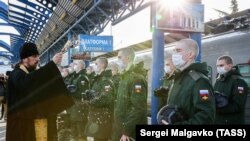 Священник и призывники на платформе железнодорожного вокзала перед отправлением к месту прохождения военной службы, аннексированный Севастополь, архивное фото