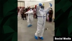 Кадр из видео, которое было распространено в социальных сетях, демонстрирует то, как медицинские работники обучают пациентов с коронавирусом танцам в больнице в китайском городе Ухань. 