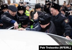 Полицейские насильно сажают в автомобиль журналистку Ингу Иманбай. Алматы, 22 февраля 2020 года.