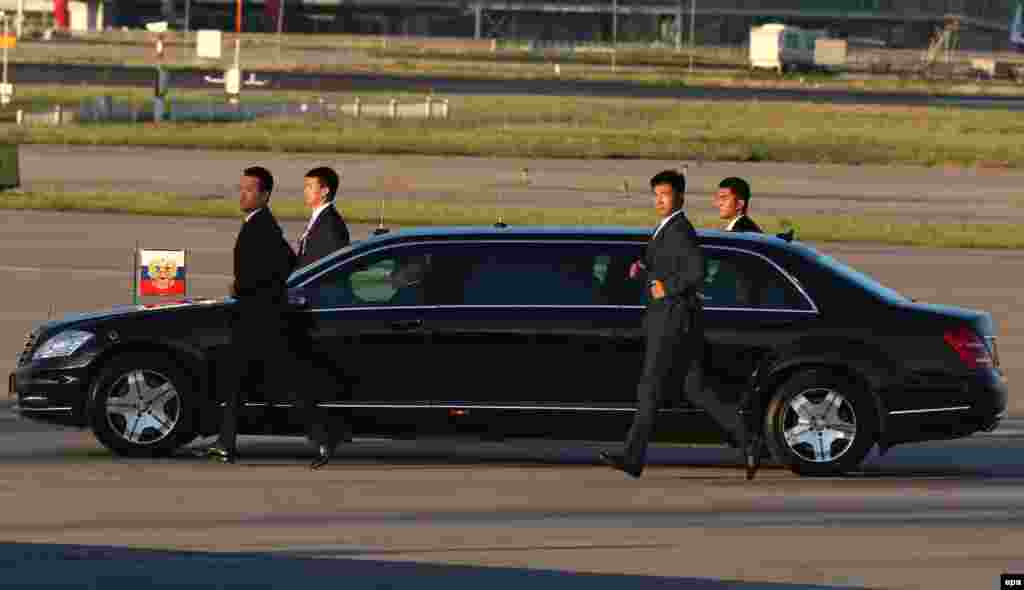 Chinese security officers guard a limousine carrying Russian President Vladimir Putin as he arrives in Beijing on September 2. (epa/Wu Hong)