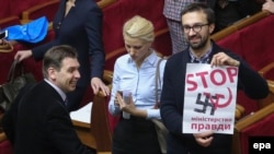 Parliamentary deputy and former journalist Serhiy Leshchenko holds a placard reading "Stop the Ministry of Truth" and equating the move with Nazi tactics as he protests during a pause in a session of the parliament in Kyiv on December 2.