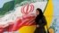 IRAN -- A woman walks in front of a mural painting depicting the Iranian flag, in the capital Tehran. August 6, 2018