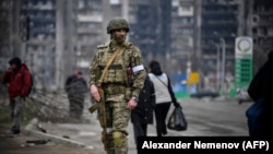 Российский солдат патрулирует на улице Мариуполя. Апрель 2022 года