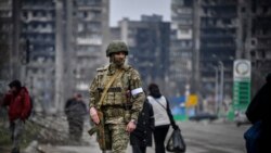 Soldat rus care patrulează pe străzile din Mariupol.