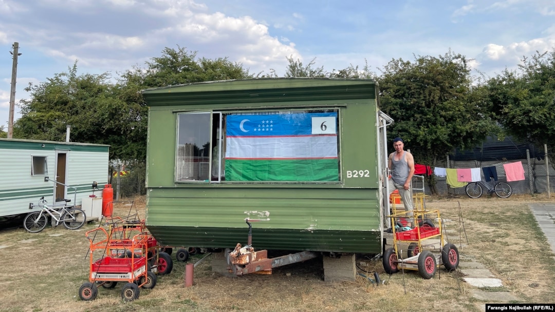 An Uzbek flag hanging at a caravan window in Britain. Most migrant workers live in caravans, shared by up to six people. 