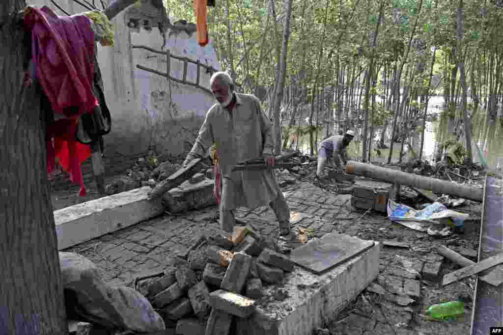 Banorët pastrojnë mbeturinat nga shtëpitë e tyre të dëmtuara nga përmbytjet, rrethi Charsada i provincës Khyber Pakhtunkhva, 29 gusht.