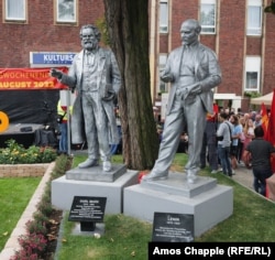 The newly unveiled monument to Marx, and the older Lenin statue.