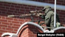 Снайпер на мурах Кремля перед початком параду на 9 травня на Красній площі у Москві, Росія.