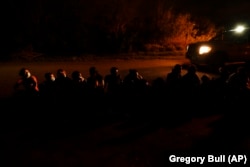 Un groupe de migrants attend le long d'une route après s'être rendu après avoir traversé la frontière américano-mexicaine à La Joya, au Texas, en mai.