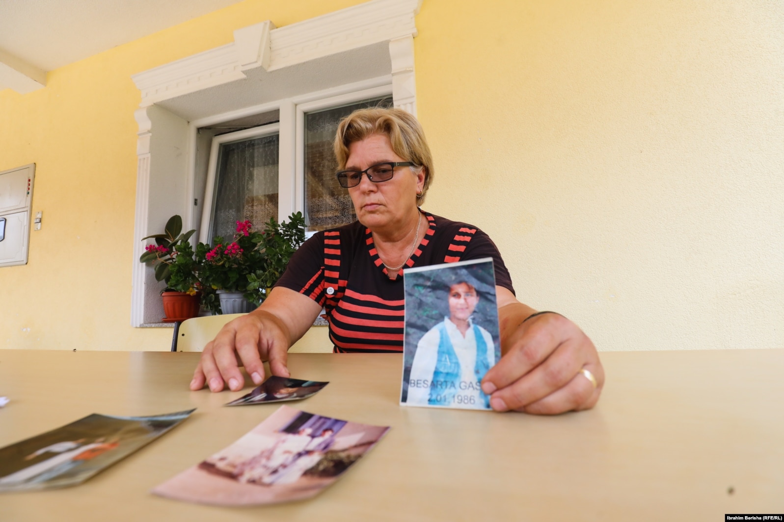 Gjyla Gashi derisa mbanë në duar fotografinë e vajzës së saj të vrarë në luftë, Besartës që ishte 13-vjeçare.