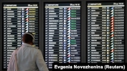 Një burrë duke marrë informacione për fluturimin e tij në Aeroportin ndërkombëtar Vnukovo të Moskës.