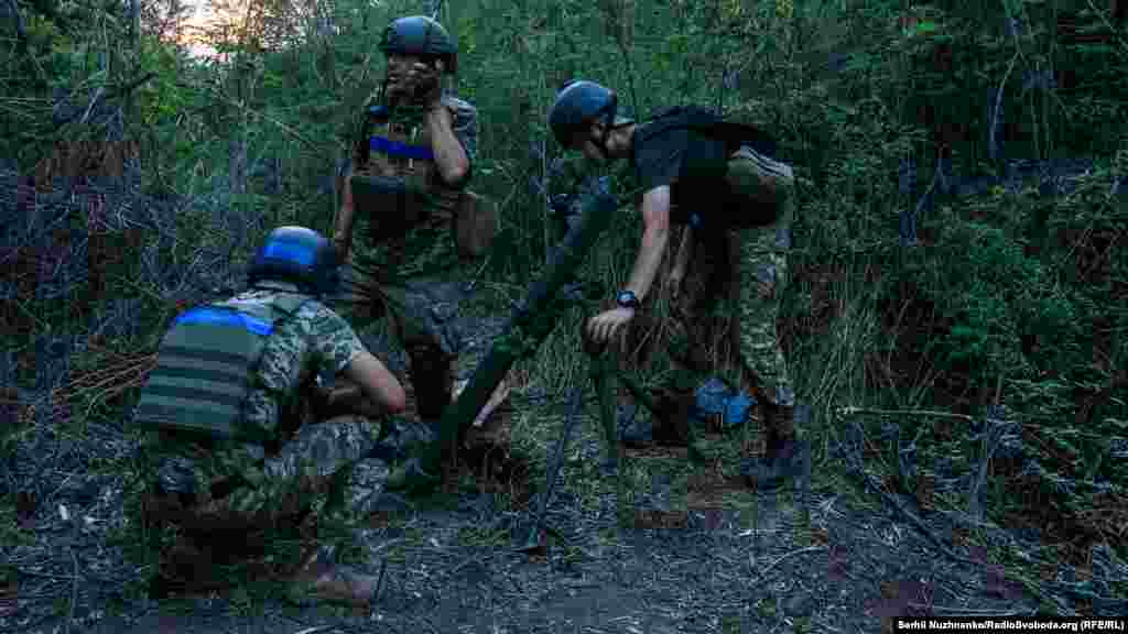 Ціль визначена. Солдати готують міни до використання і наводять міномет по прицілу