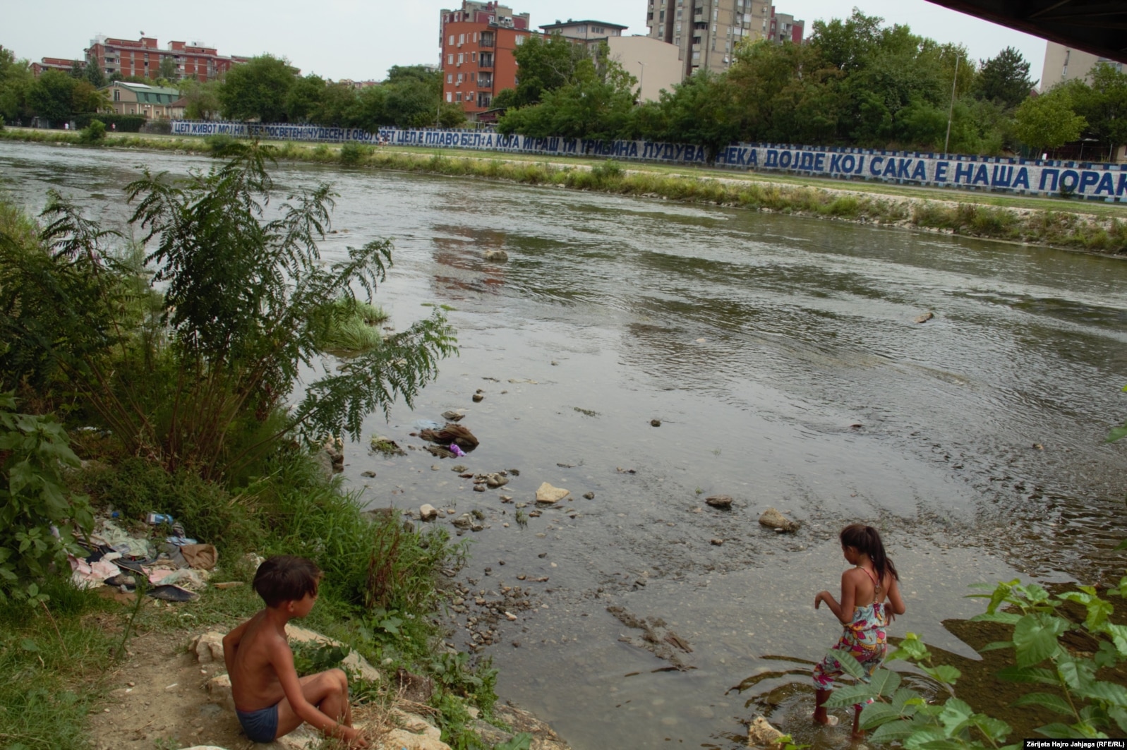 Fëmijët duke u larë në lumin e ndotur të Vardarit në Shkup.