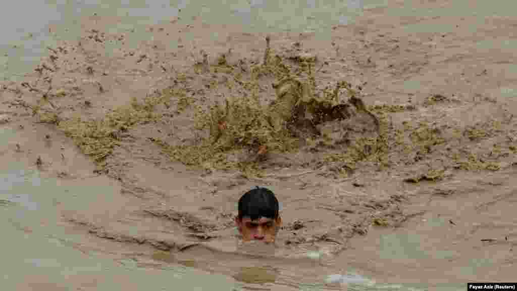 Muškarac u poplavnim vodama, nakon kiše i poplava tokom sezone monsuna u Čarsadi, Pakistan, 27. august.