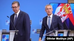 Serbian President Aleksandar Vucic (left) and NATO Secretary-General Jens Stoltenberg arrive for a media conference at NATO headquarters in Brussels on August 17.