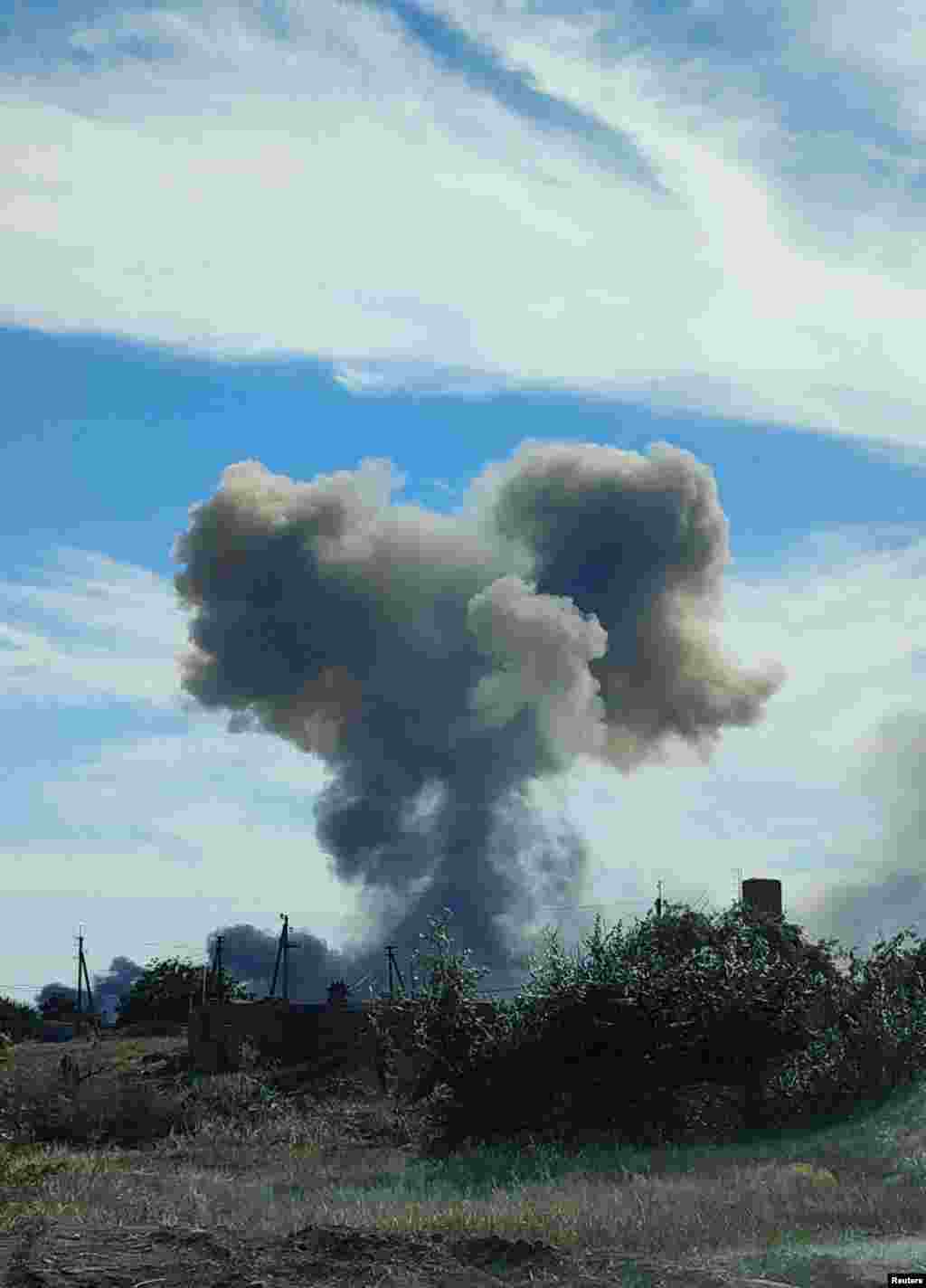 В воздух поднимается дым от взрывов на военном аэродроме в поселке Новофедоровка вблизи города Саки в оккупированном Крыму. Фото от 9 августа 2022 года