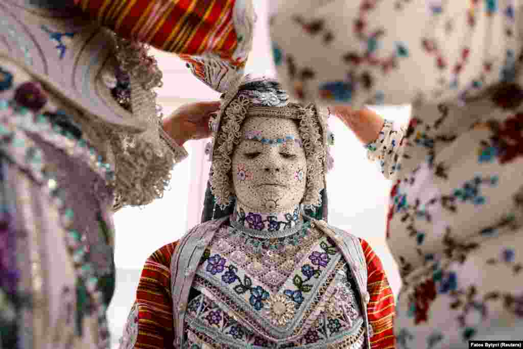 Melissa Guerrero, a U.S. citizen of Mexican origin, wears traditional wedding makeup and a traditional costume as she is prepared for her wedding ceremony in the village of Donje Ljubinje, near Prizren, Kosovo.