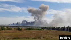 Coloana de fum care se ridica de la baza aeriană rusă din estul peninsulei Crimeea, unde s-au înregistrat mai multe explozii, Ucraina, 9 august 2022.