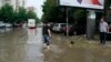 Një qytetar duke u përpjekur të zhbllokojë ujëmbledhësit në një rrugë në Shkup, 30 gusht 2022. 