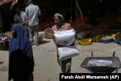 A man in Somalia carries a sack of wheat flour imported from Turkey.