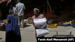 A man carries a sack of wheat flour imported from Turkey in Mogadishu, Somalia, Thursday.