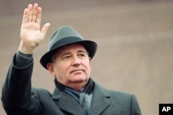 Președintele sovietic Mihail Gorbaciov salută mulțimea de la tribuna din Piața Roșie, de Ziua Revoluției, la Moscova, pe 7 noiembrie 1989.