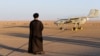یک روحانی در جریان یک رزمایش نظامی در نقطه‌ای نامعلوم از ایران رو به یک پهپاد ایستاده است